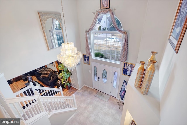 foyer featuring an inviting chandelier and a high ceiling