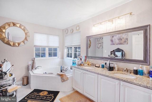 bathroom featuring tile patterned floors, vanity, and tiled tub