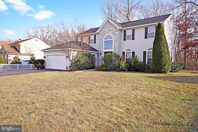 colonial home featuring a garage and a front lawn