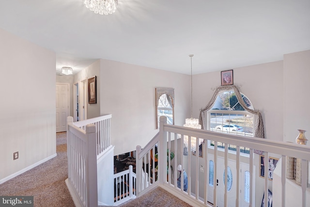 staircase featuring a chandelier and carpet floors