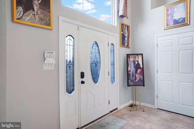 entrance foyer with a high ceiling and light tile patterned floors