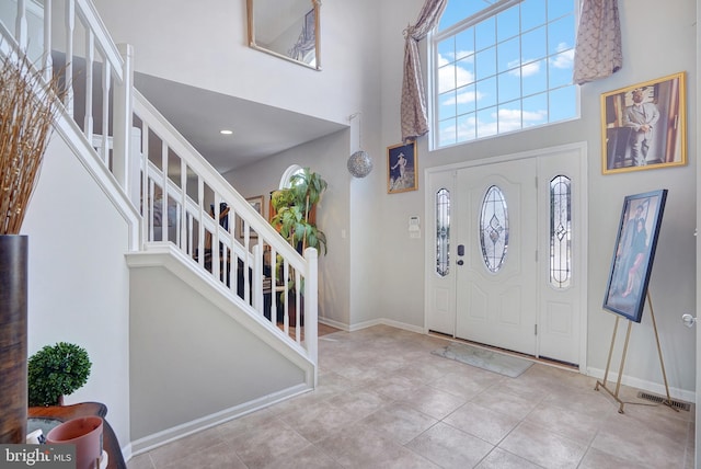 entrance foyer featuring light tile patterned floors and a high ceiling