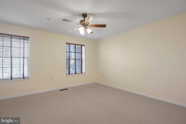 unfurnished room with ceiling fan, plenty of natural light, and carpet flooring