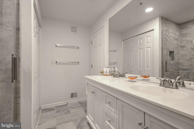 bathroom with vanity and a shower with shower door