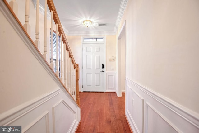 foyer entrance with crown molding and light wood-type flooring