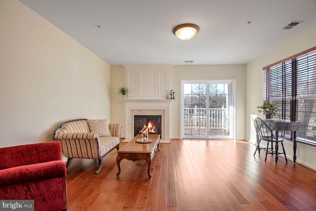 sitting room featuring a wealth of natural light, hardwood / wood-style floors, and a fireplace