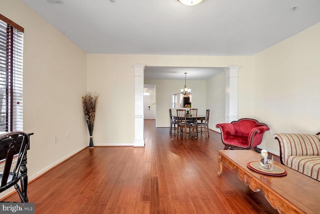 interior space with hardwood / wood-style flooring, a healthy amount of sunlight, and ornate columns