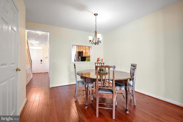 dining room featuring hardwood / wood-style flooring and a chandelier