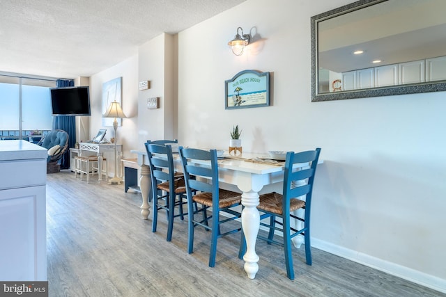 dining room with a textured ceiling and wood-type flooring