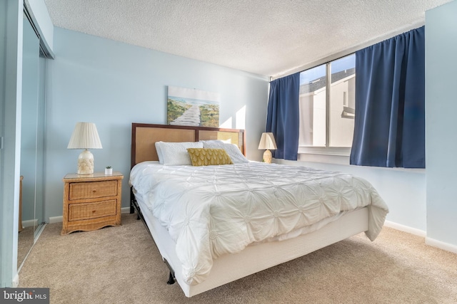 bedroom featuring a closet, a textured ceiling, and light colored carpet