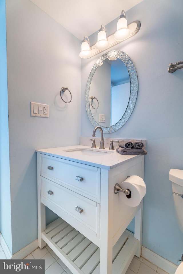 bathroom featuring toilet, vanity, and tile patterned flooring