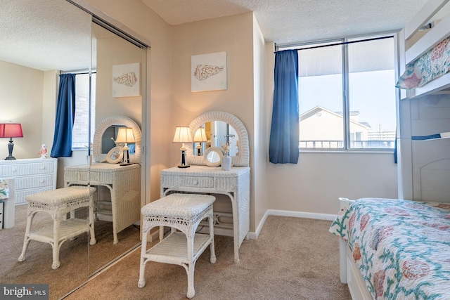 bedroom featuring a closet, a textured ceiling, and light carpet