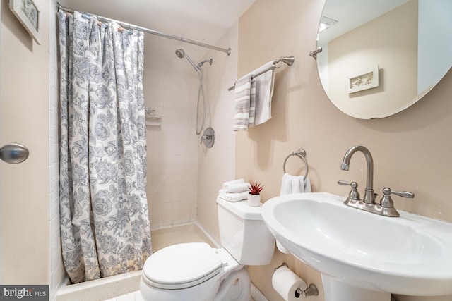 bathroom featuring sink, curtained shower, and toilet