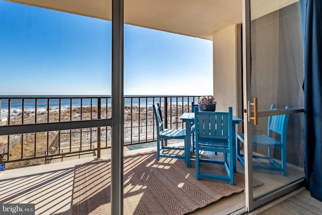 balcony featuring a water view and a view of the beach