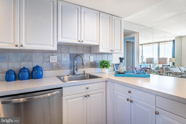 kitchen featuring stainless steel dishwasher, white cabinetry, and sink