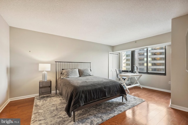 bedroom with hardwood / wood-style floors and a textured ceiling