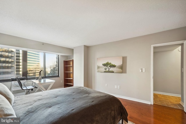 bedroom featuring dark hardwood / wood-style flooring and a textured ceiling