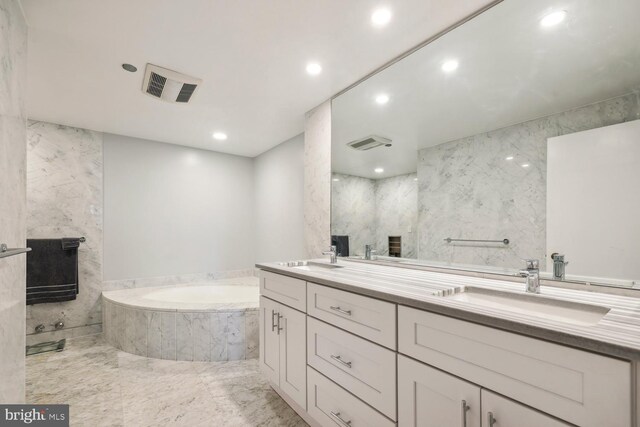 bathroom featuring vanity, tiled bath, and a fireplace