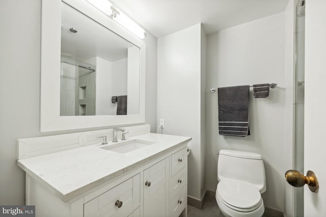 bathroom featuring vanity, an enclosed shower, and toilet