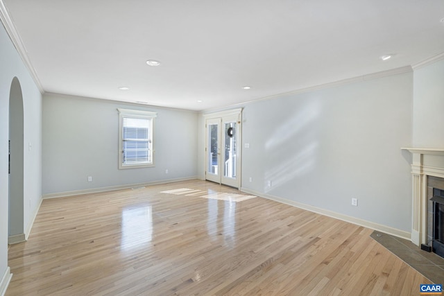 unfurnished living room featuring light wood-type flooring, french doors, and ornamental molding