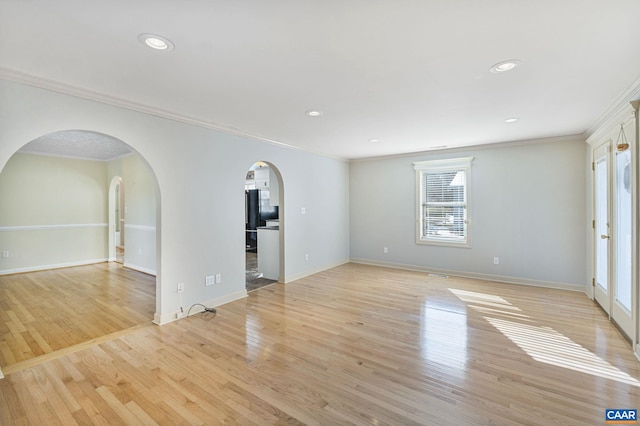 spare room with ornamental molding and light wood-type flooring