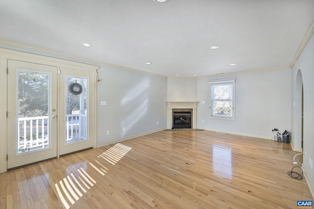 unfurnished living room with light hardwood / wood-style floors and crown molding