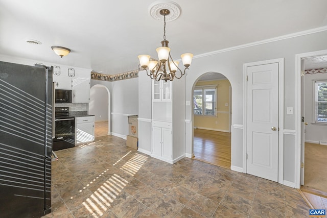 kitchen featuring crown molding, white cabinets, black appliances, and plenty of natural light