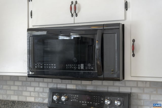 interior details featuring backsplash and white cabinetry