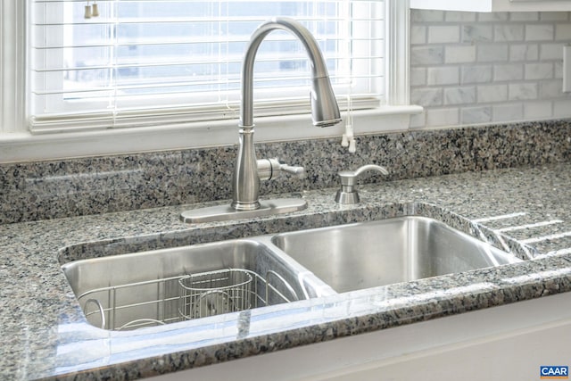 details with sink, stone counters, and decorative backsplash