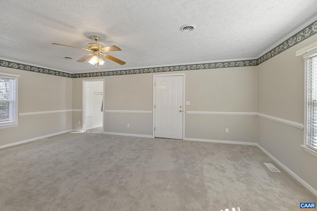 carpeted empty room featuring ceiling fan and a textured ceiling