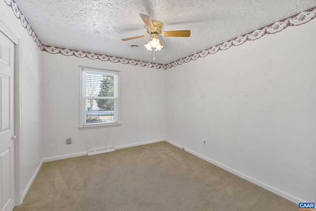 unfurnished room with a textured ceiling, ceiling fan, and carpet floors