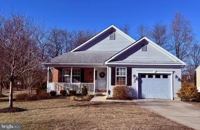 view of front of house with covered porch, a front lawn, and a garage