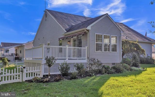 view of property exterior featuring covered porch and a lawn