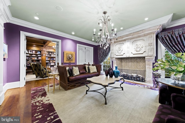 living room with built in shelves, ornamental molding, a chandelier, and light wood-type flooring