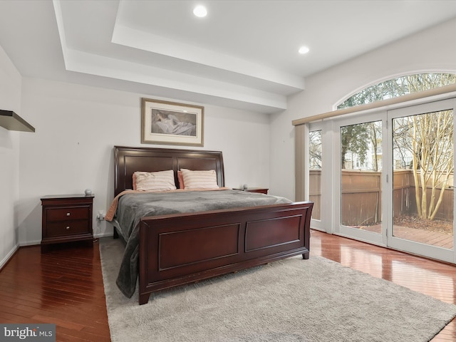 bedroom featuring baseboards, recessed lighting, wood finished floors, and access to exterior