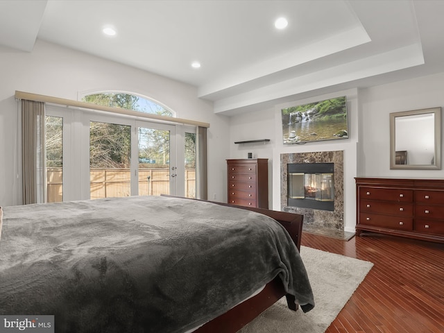 bedroom with a high end fireplace, access to outside, dark wood-style flooring, and recessed lighting