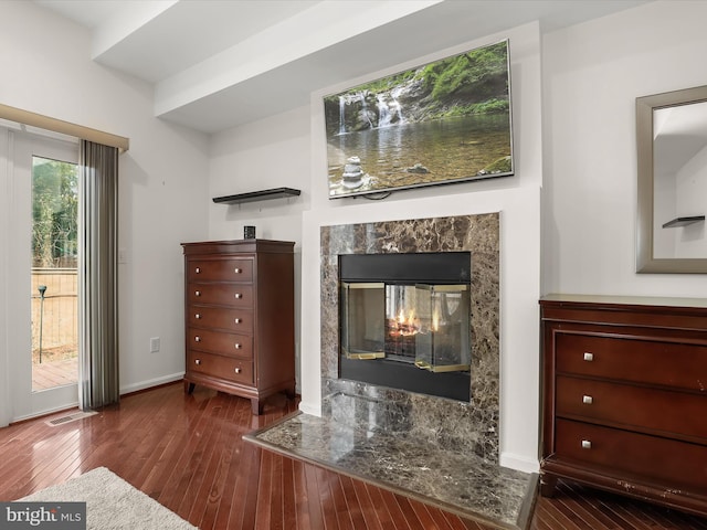 interior space with wood finished floors, visible vents, baseboards, and a premium fireplace