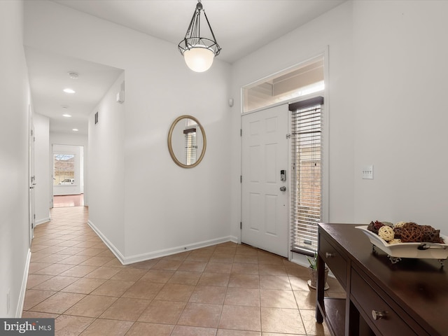 foyer entrance with light tile patterned floors and baseboards