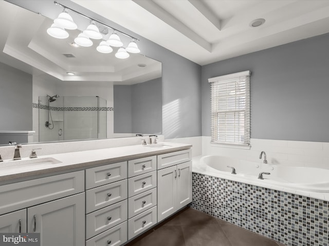 full bath with double vanity, tile patterned flooring, a raised ceiling, and a sink