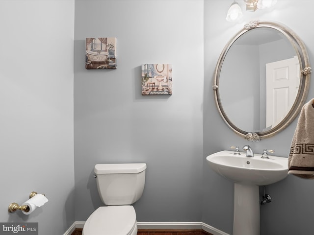 bathroom featuring toilet and baseboards