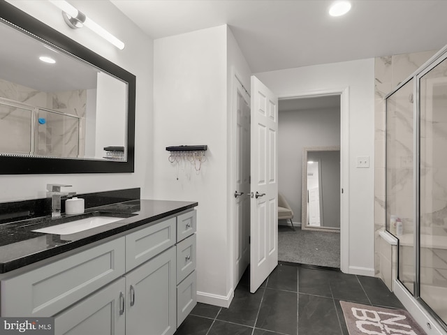 full bath featuring ensuite bathroom, vanity, baseboards, tile patterned floors, and a stall shower