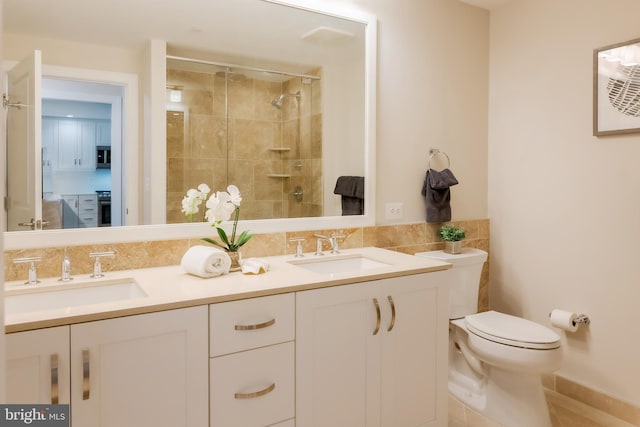 bathroom featuring tiled shower, vanity, and toilet