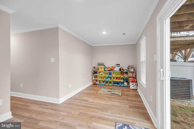 playroom featuring light wood-type flooring and crown molding