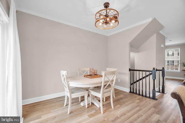 dining area featuring an inviting chandelier, ornamental molding, and light hardwood / wood-style flooring