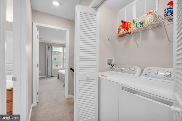 clothes washing area with separate washer and dryer and light colored carpet