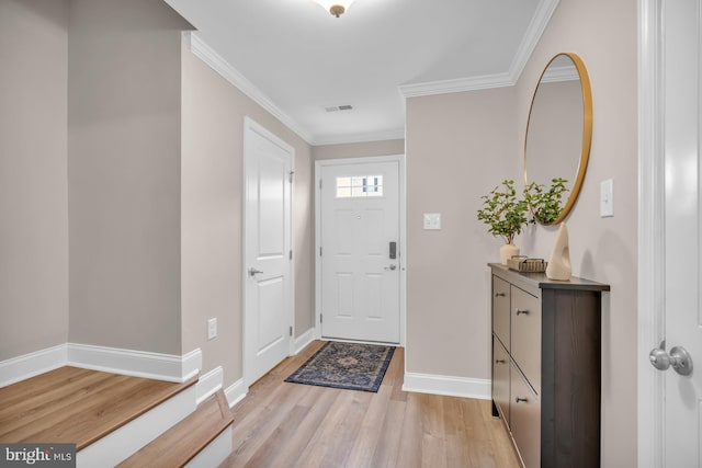 foyer entrance with light wood-type flooring and ornamental molding