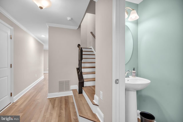 interior space featuring hardwood / wood-style flooring, ornamental molding, and sink