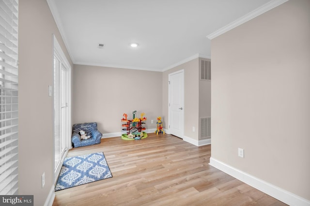 rec room featuring ornamental molding and light hardwood / wood-style floors