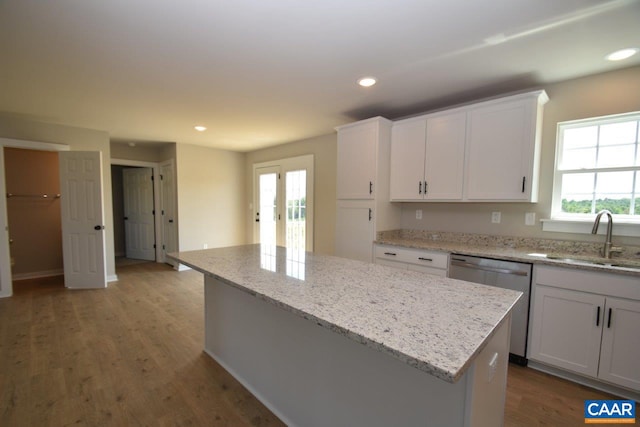 kitchen with white cabinets, a center island, dishwasher, and sink