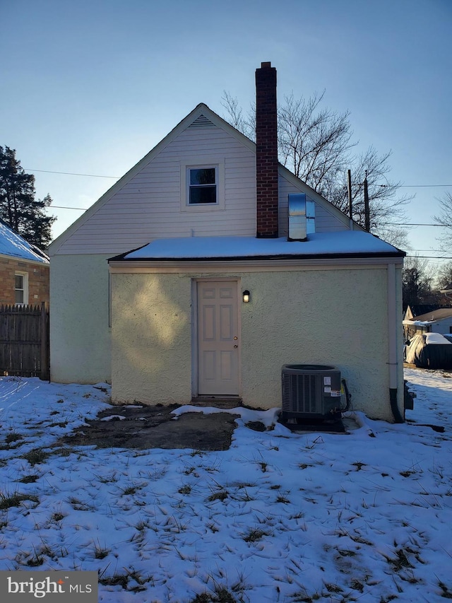 snow covered rear of property with cooling unit